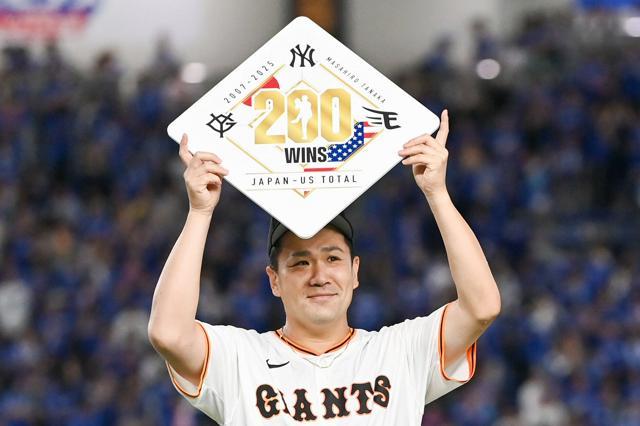 日米通算200勝の記録のプレートを持つ田中将大投手
