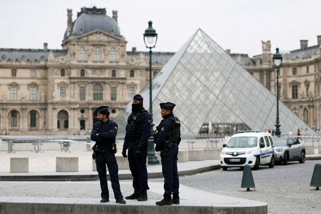 ルーブル美術館の前で警戒して仕事をする警察官