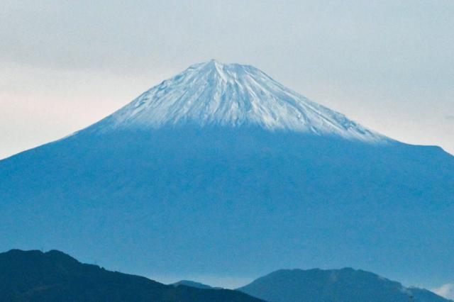 山の頂上に雪が積もって白くなった富士山の様子