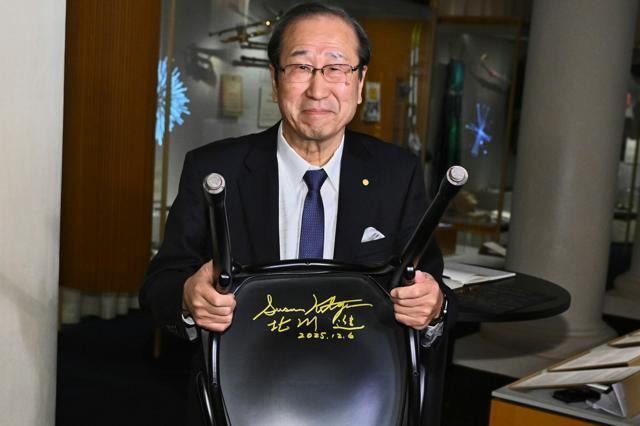 2025年12月6日、スウェーデン・ストックホルムのノーベル博物館のカフェの椅子にサインをしたノーベル化学賞受賞者の北川進さん。TT通信提供