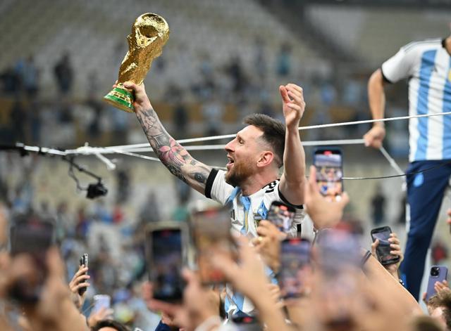 2022年、ワールドカップのカタール大会で優勝しトロフィーを掲げて喜ぶアルゼンチンのメッシ