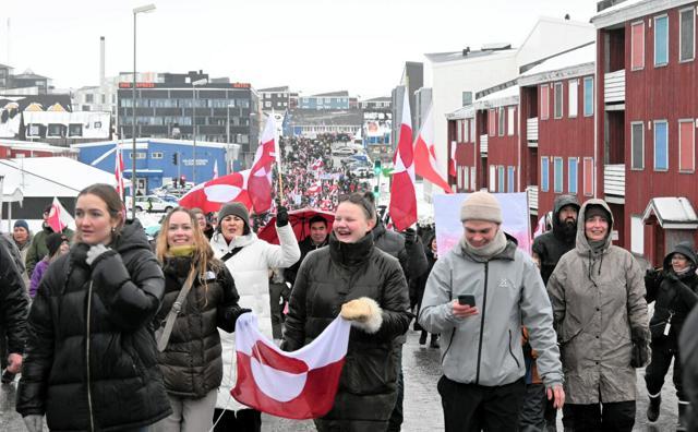 デンマークの自治領グリーンランドの中心都市ヌークで2026年1月17日、島の領有を求めるトランプ米大統領への抗議デモに参加した市民。グリーンランドの旗を掲げて行進した