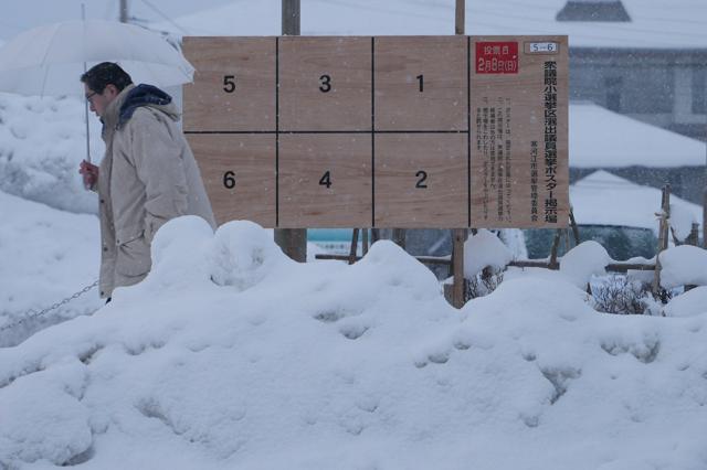 雪が積もる中、設置された選挙ポスターの掲示場