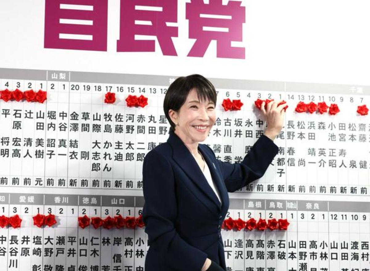 自民党の開票センターで、当選確実になった候補者名に笑顔で花をつける高市早苗首相