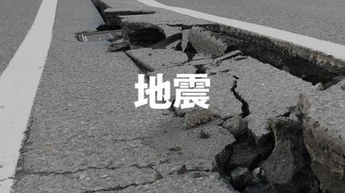 ひび割れた道路の写真の中央に「地震」の文字が入っている
