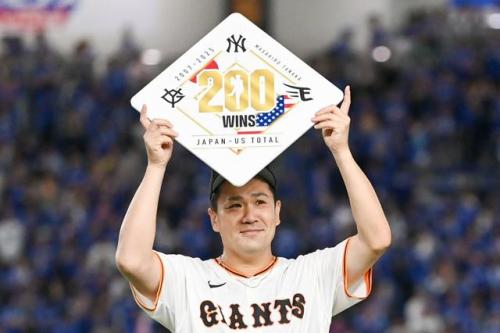 日米通算200勝の記録のプレートを持つ田中将大投手