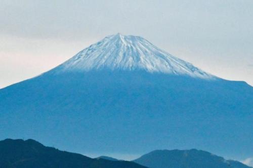 山の頂上に雪が積もって白くなった富士山の様子
