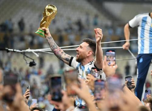 2022年、ワールドカップのカタール大会で優勝しトロフィーを掲げて喜ぶアルゼンチンのメッシ