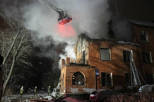 ウクライナの首都キーウで2026年1月9日、ロシア軍の攻撃を受けた住宅で消火活動をする消防隊